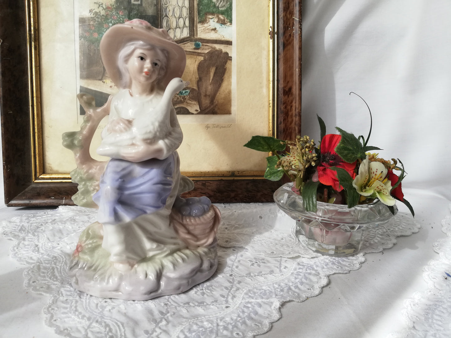 Porzellanfigur Mädchen mit Gans auf Stein. Neben einem Blumenbouquet sitzend.