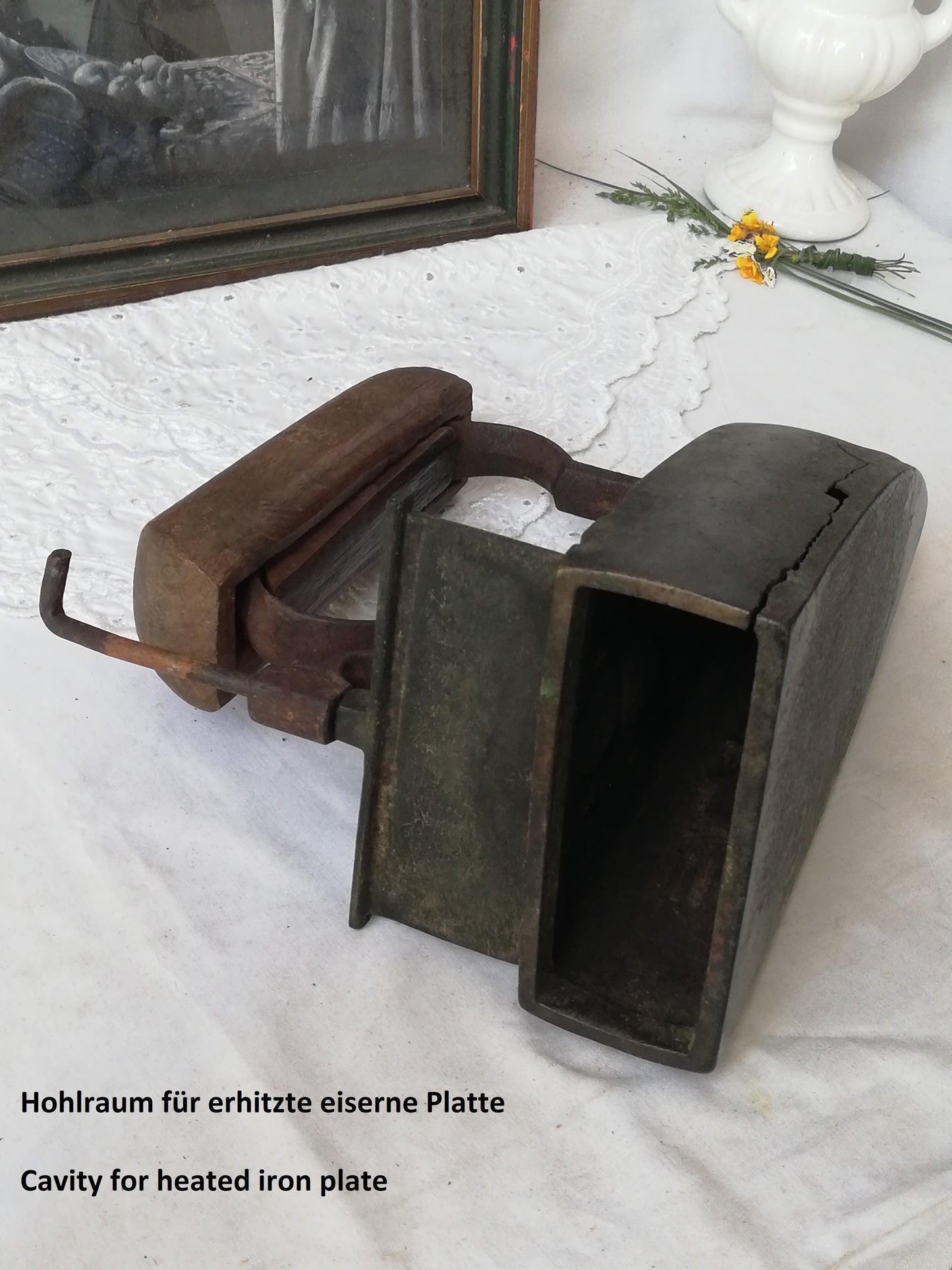 Vintage Bügeleisen mit Ochsenzunge, dekoratives Sammlerstück. Liegned mit geeöffneter Schiebetür.