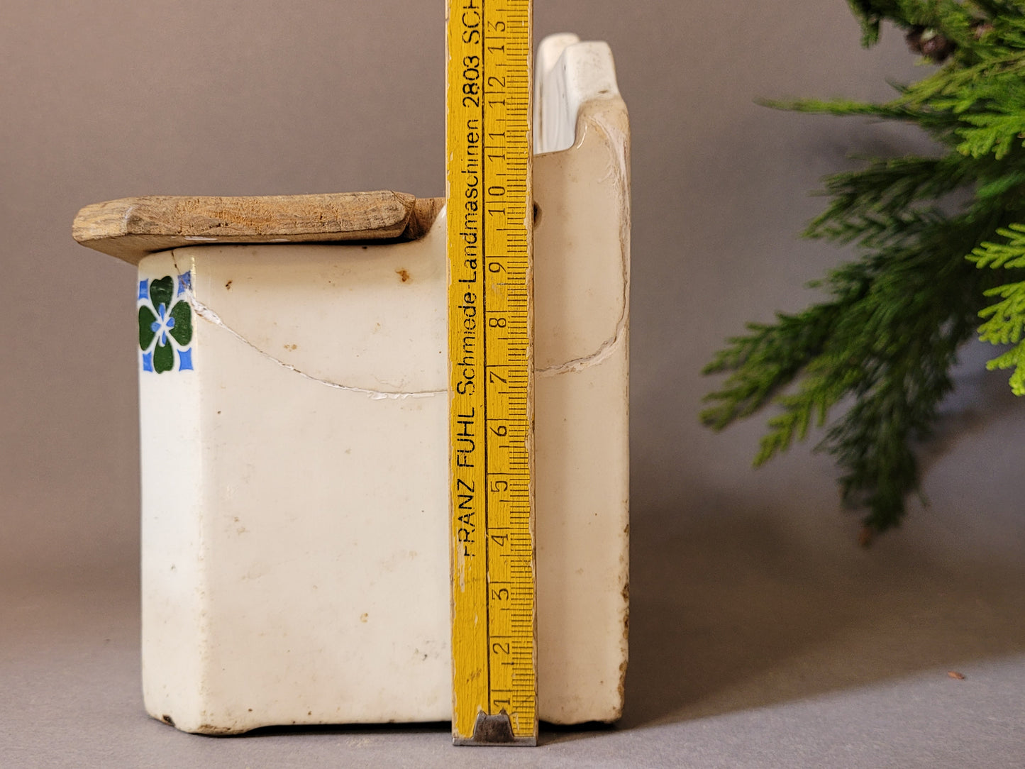 Antike Salzbox aus der Manufaktur Wilhelmsburg mit Kleeblatt. Ansicht von von deer Seite mit  Metermaß, um die Höhe der Keramikbox zu messen,