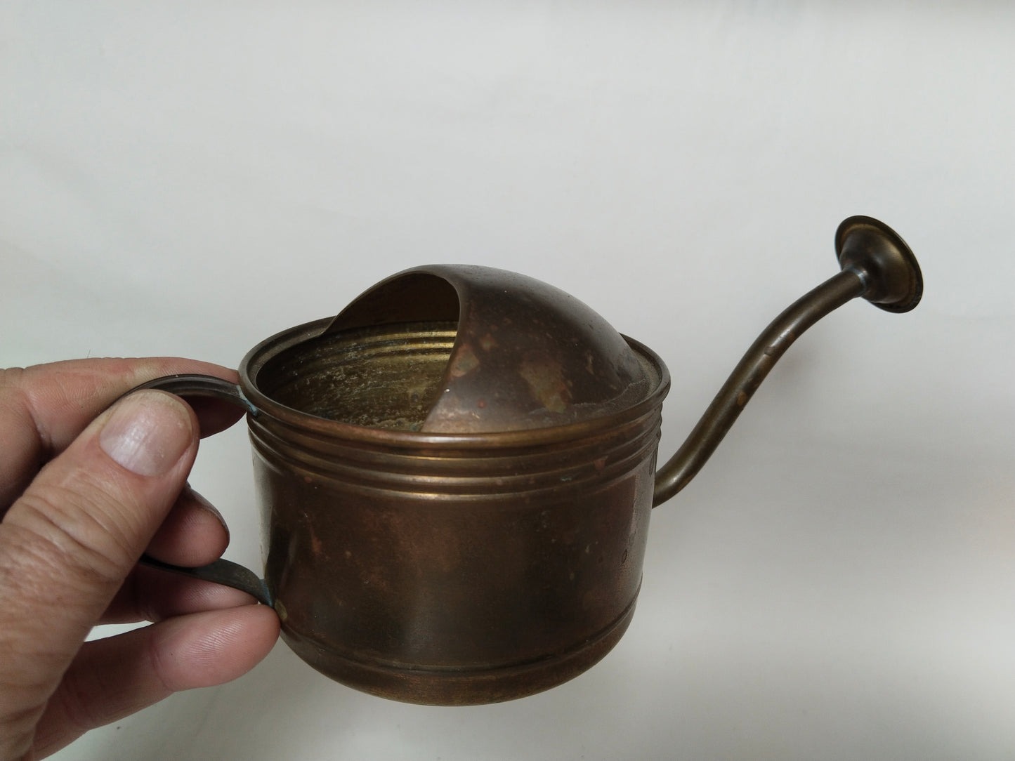 Gießkanne in der Hand gehalten, Größenvergleich, kleines Vintage Messingstück
