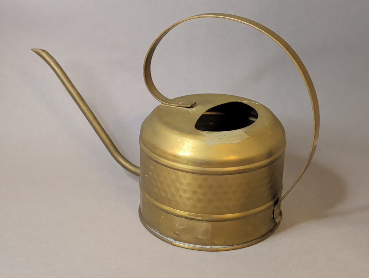 Vintage Gießkanne aus Messing von vorne, Gießrohr nach links, Bügel nach rechts geschwungen
