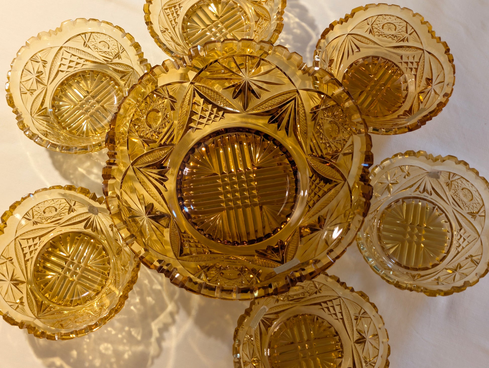 Bernstein-Schliffglas-Set von oben auf hellem Untergrund, große Schale mit sechs Schälchen, Vintage amber
