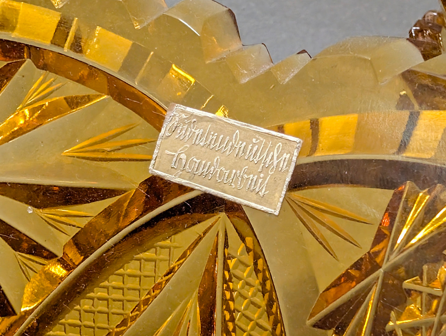 Handgeschriebenes Papieretikett auf bernsteinfarbenem Schliffglas, Vintage Fundstück Herkunftsnachweis
