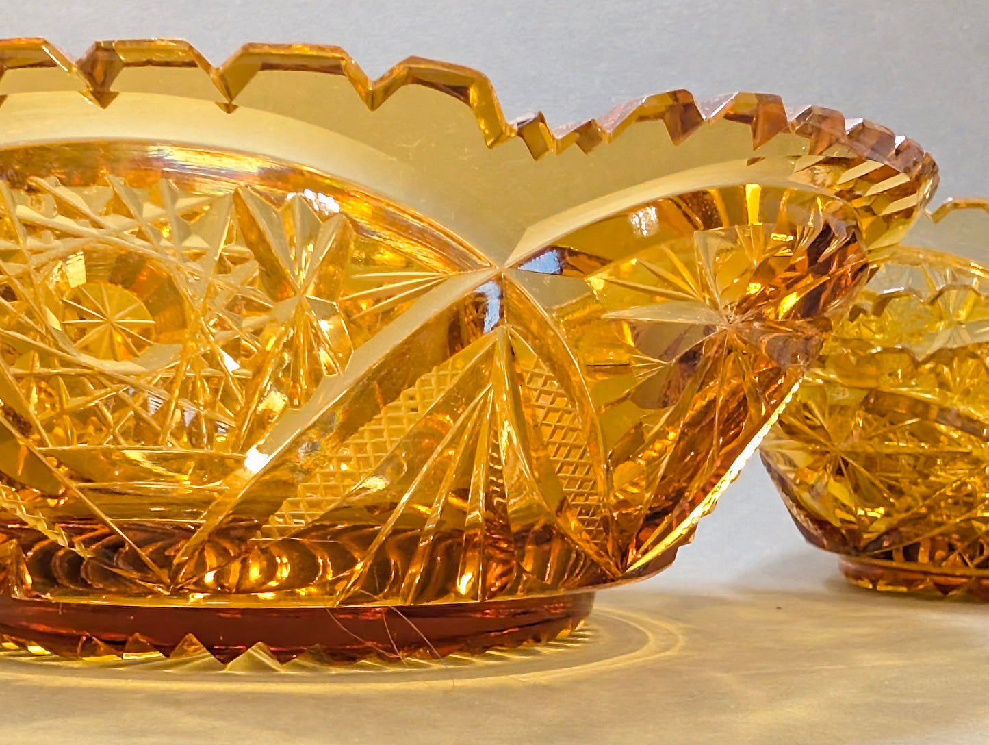 Zwei bernsteinfarbene Schliffglas-Schalen im Profil, gezackter Sägezahnrand, Vintage Kristall amber
