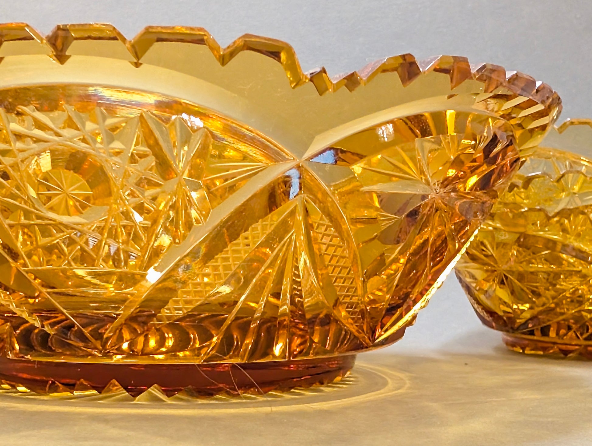 Zwei bernsteinfarbene Schliffglas-Schalen im Profil, gezackter Sägezahnrand, Vintage Kristall amber
