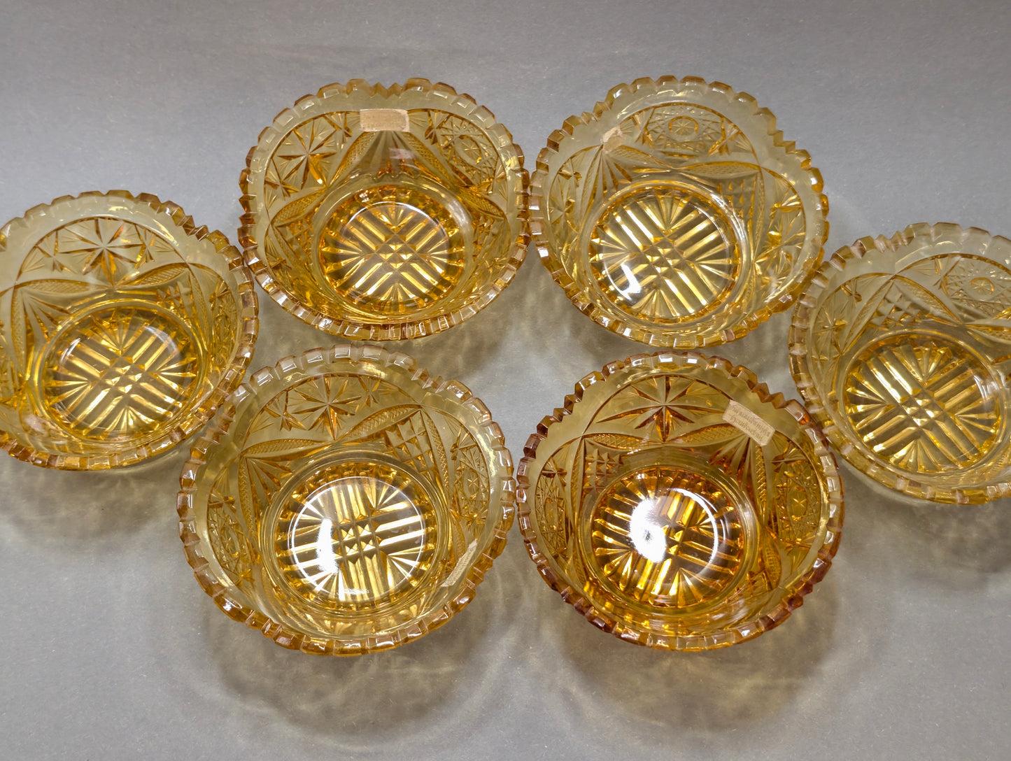 Fünf bernsteinfarbene Schliffglas-Schälchen von oben, Sternmuster im Boden, Vintage Kristallglas