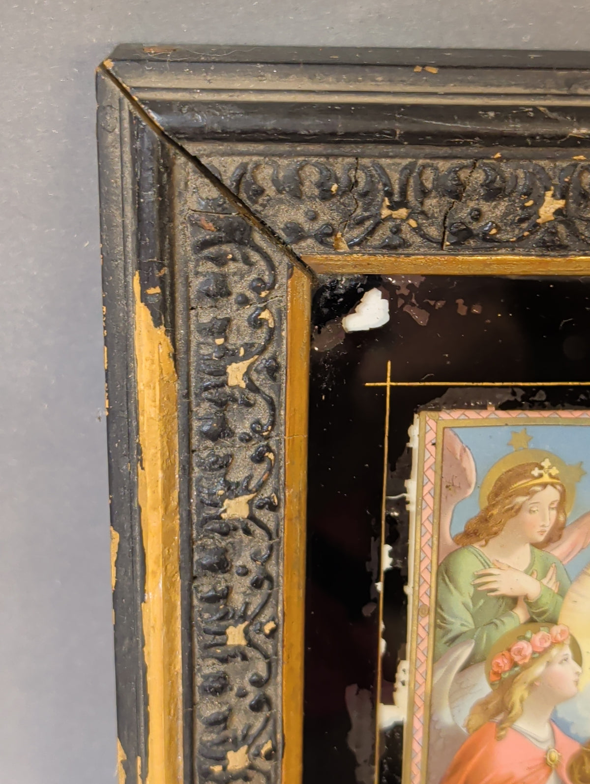 Rahmenecke mit schwarzem Rankenrelief, vergoldeter Innenleiste und Abplatzungen am Hinterglas