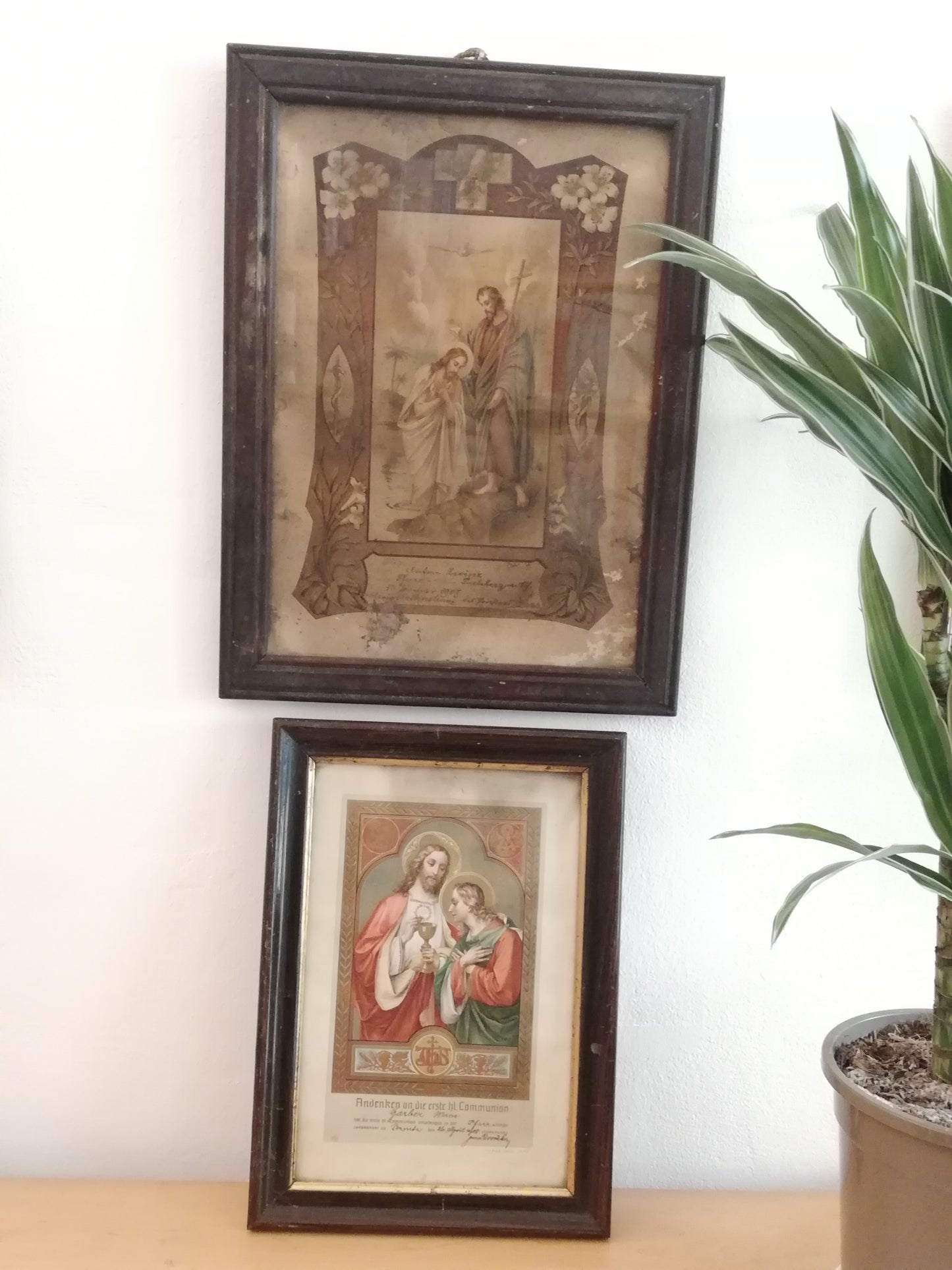 Antikes Heiligenbild katholische Taufe 1907. Bild hängt an der Wand zusammen mit einem alten Kommunionsbild.