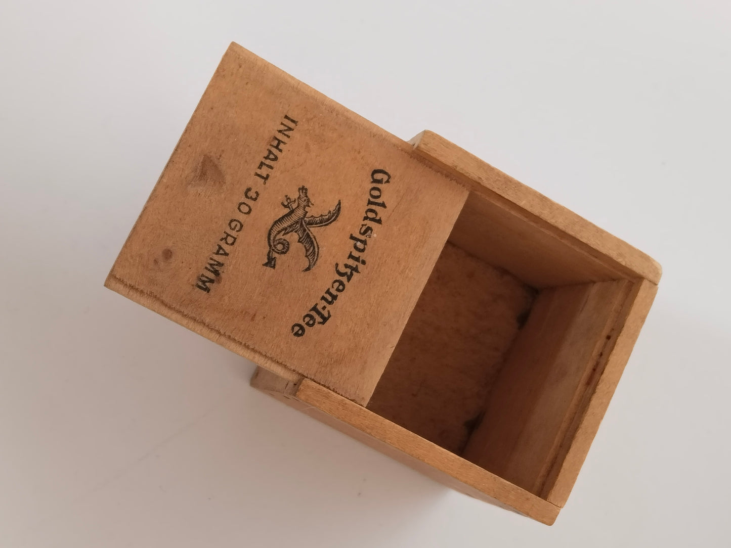 Geöffnete Holz-Teedose mit herausgezogenem Schiebedeckel und leerem Innenraum

