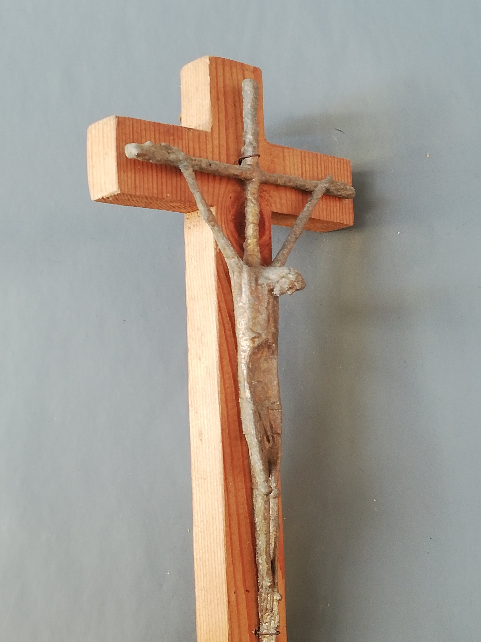 Handgeschnitztes Holzkreuz mit Christus. Schräg links aufgenommen.