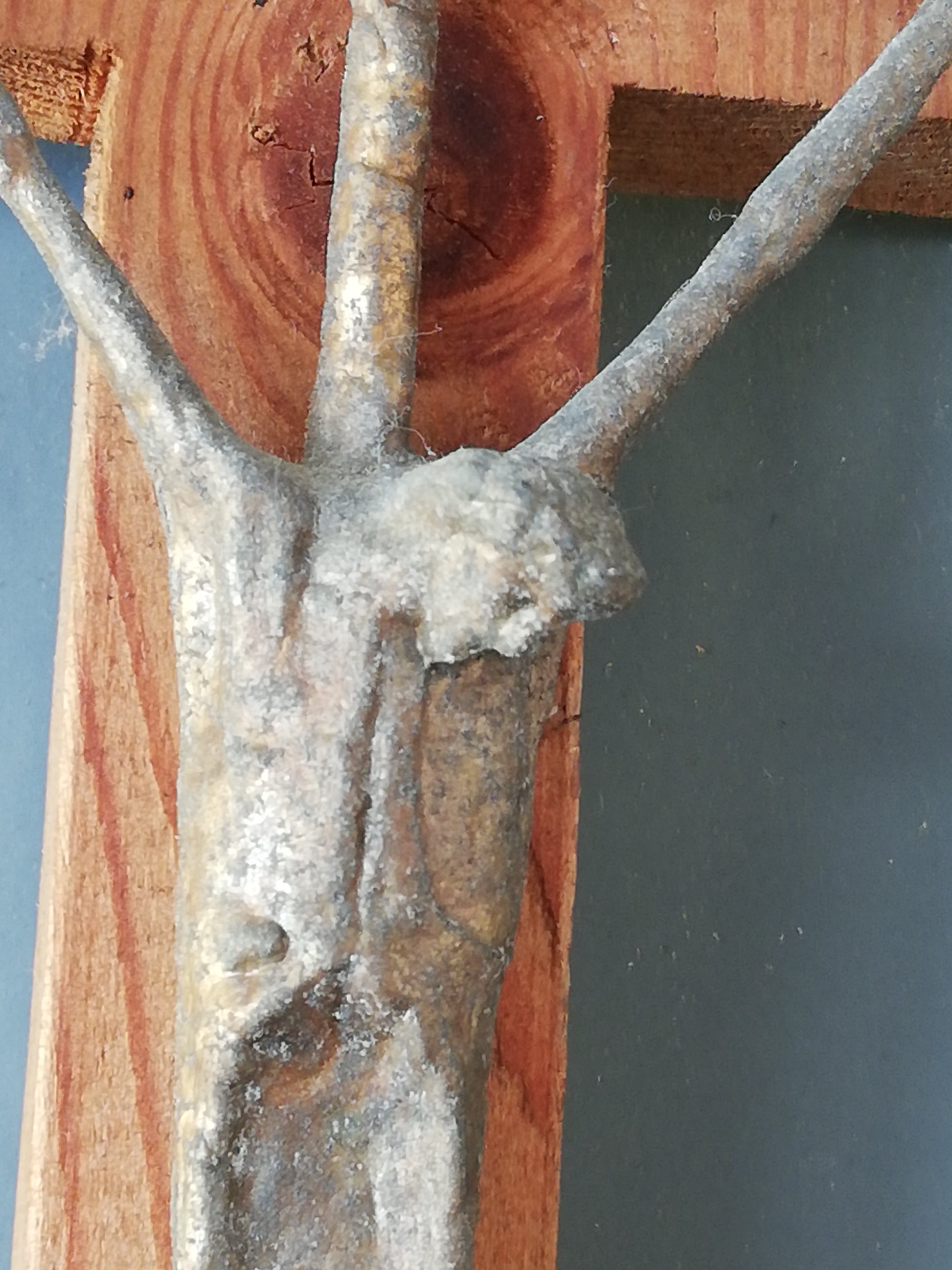 Handgeschnitztes Holzkreuz mit Christus. Detailaufnnahme des leidenden Gesichtes von Chrsitus.