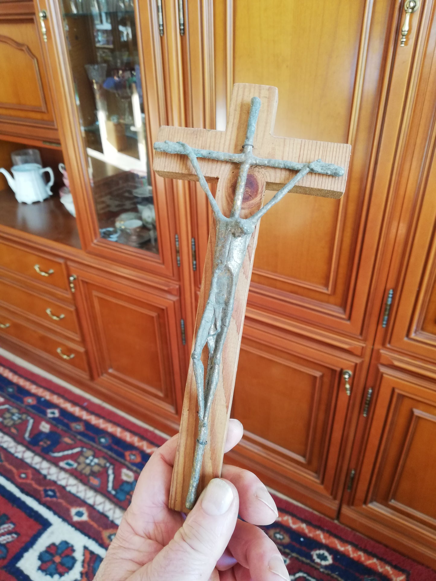 Handgeschnitztes Holzkreuz mit Christus. In der Hand geehalten.