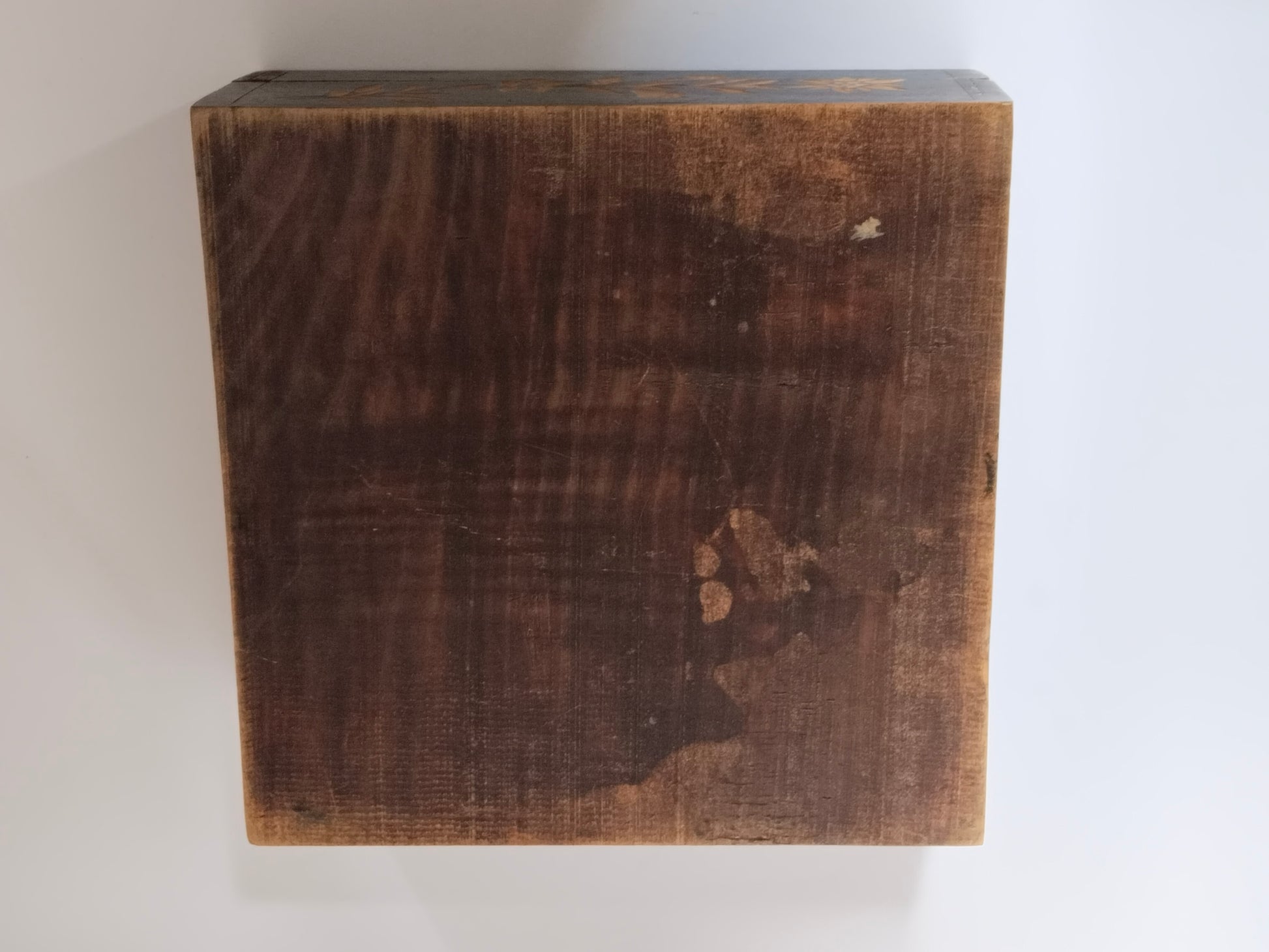 Unterseite der Holzschatulle aus hellem Weichholz mit Altersspuren und Flecken