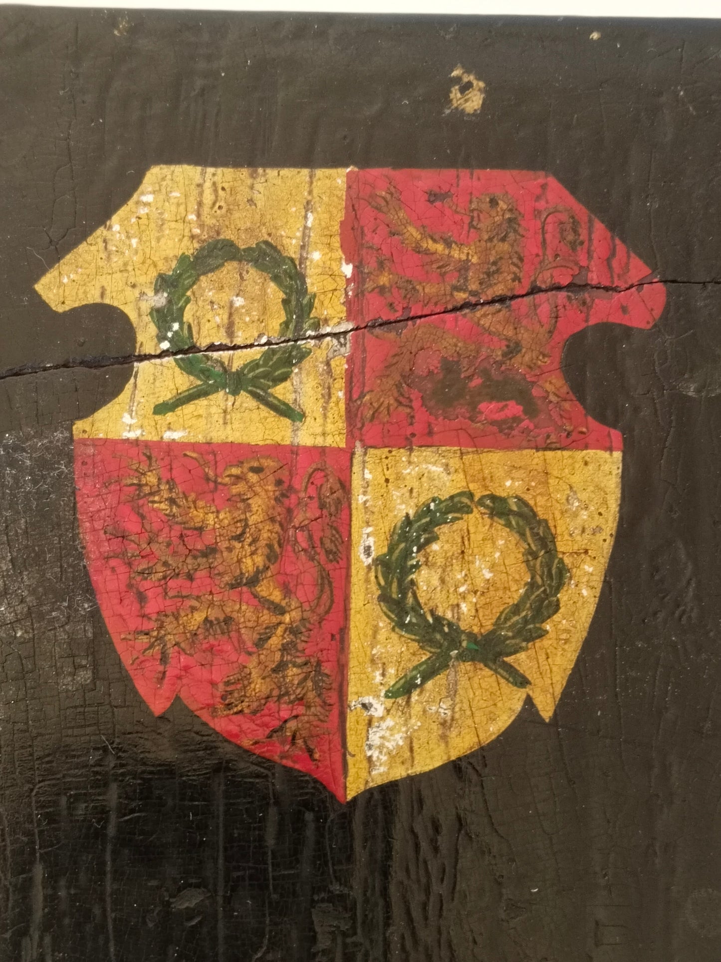 Draufsicht auf das handgemalte Wappen, gevierter Schild in Rot und Gold auf schwarzem Lack. Detailansicht.
