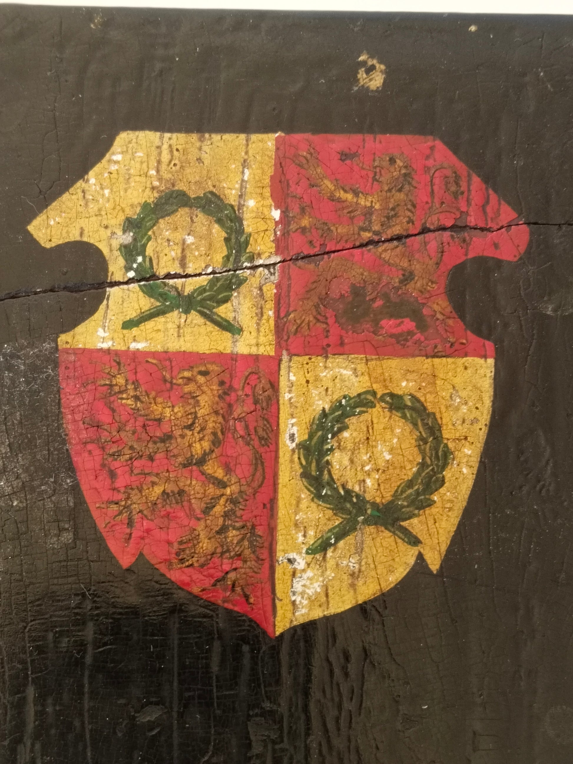 Draufsicht auf das handgemalte Wappen, gevierter Schild in Rot und Gold auf schwarzem Lack. Detailansicht.
