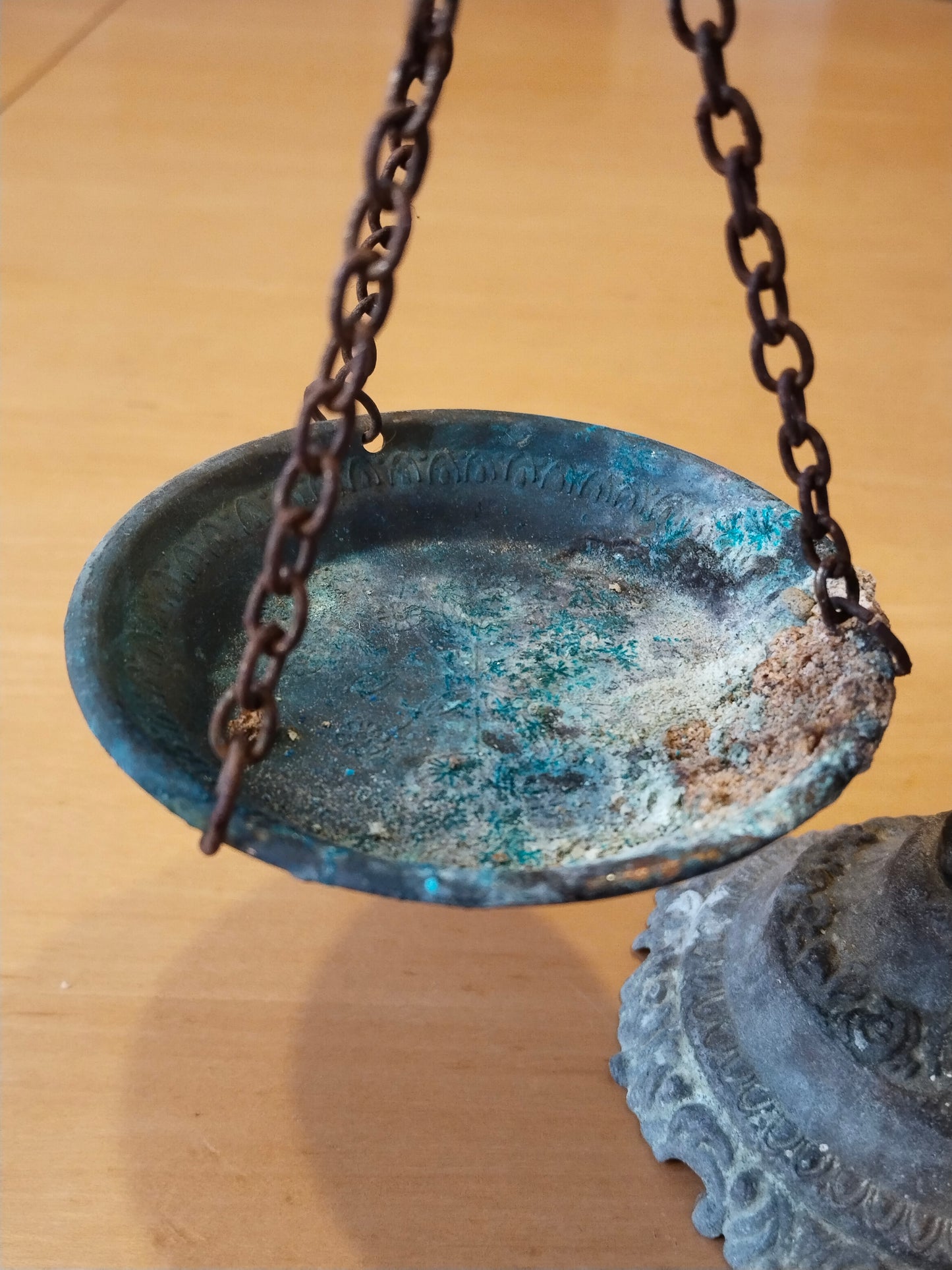 Nahaufnahme linke Schale mit blaugrüner Kupferpatina und alten Eisenketten