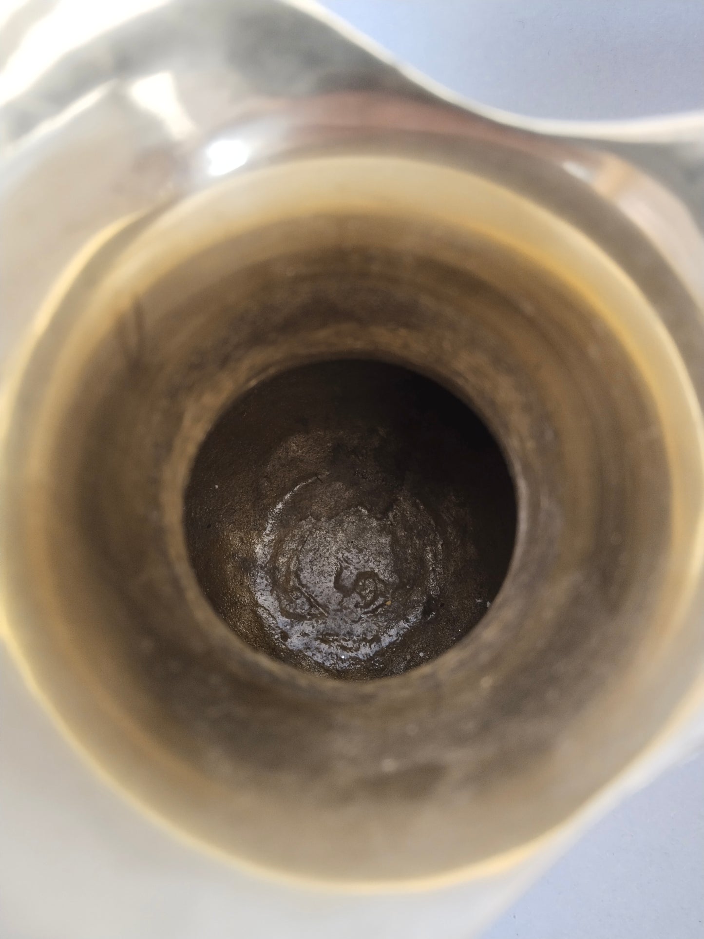 Blick von oben in das dunkle, originale Innenleben des Messing-Deko-Objekts