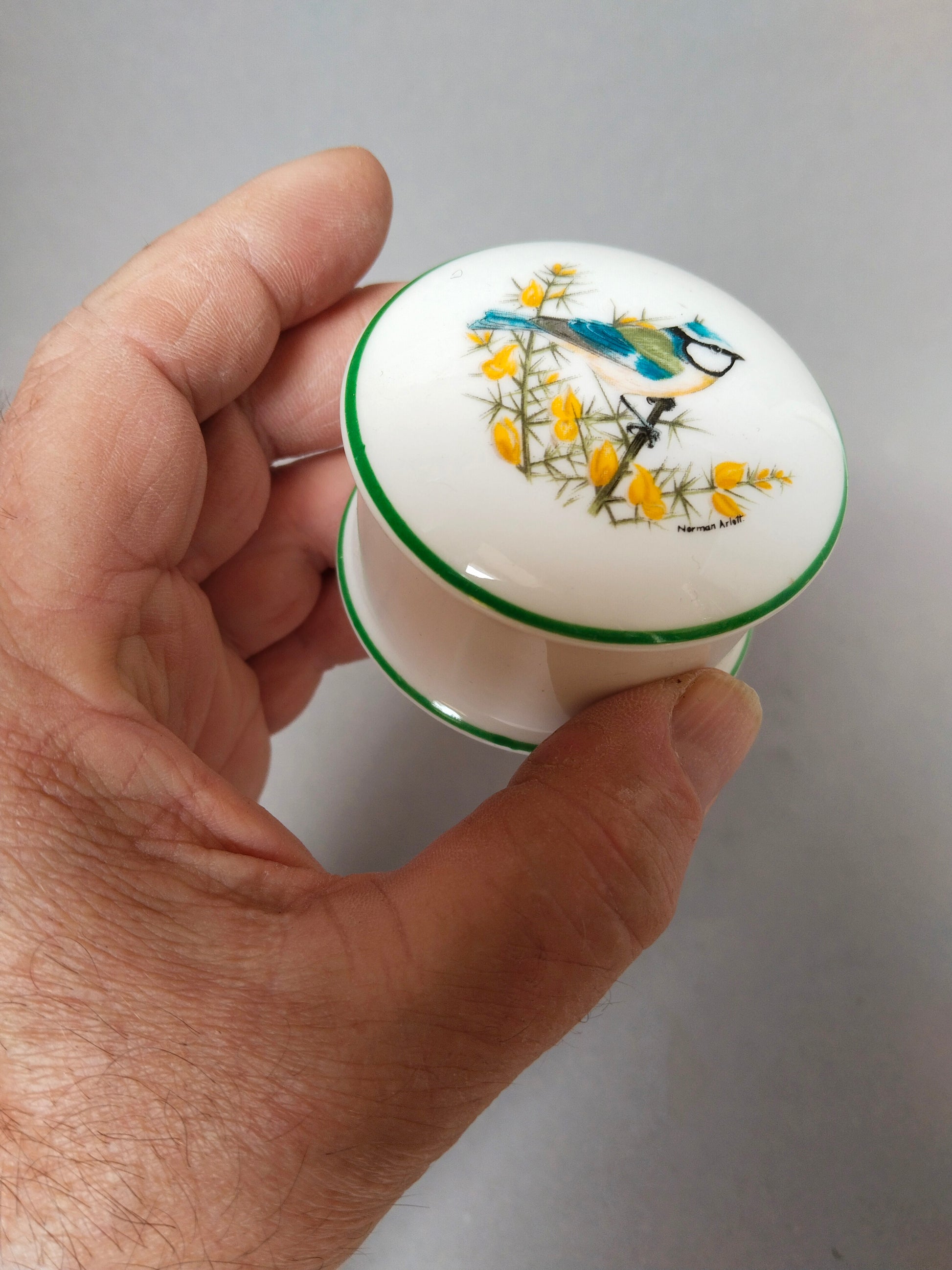 Die kleine Porzellandose wird in einer Hand gehalten, um die zierliche Größe von 5,5 cm zu veranschaulichen.