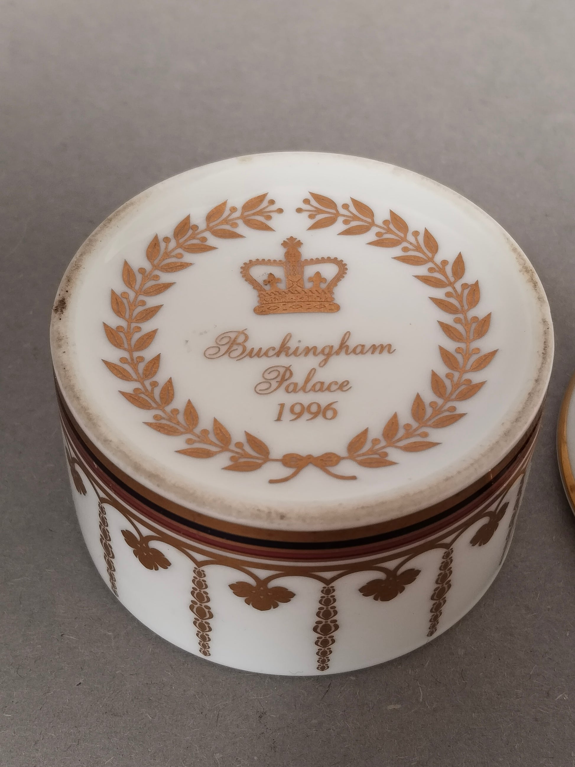 Detailaufnahme der Unterseite der weißen Dose mit dem makellosen goldenen Herstellersiegel.