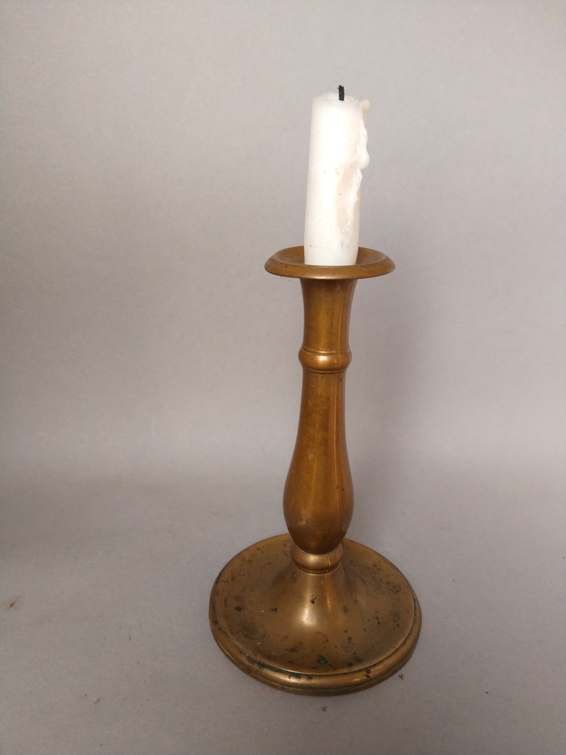 Vintage Messing-Kerzenständer mit weißer Stabkerze, Ambiente-Aufnahme, wohnliche Stimmung