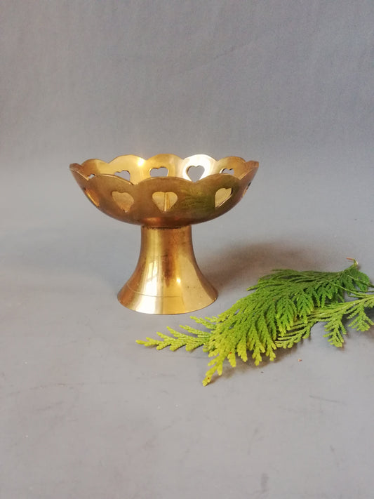 Kleiner Vintage Messing Kerzenständer mit eingestanzten Herzen neben Dekozweig.