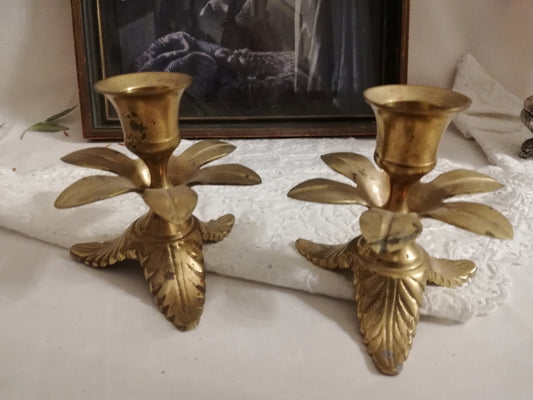 Zwei antike Messing-Kerzenständer mit Akanthusblatt-Fuß auf weißer Spitzendecke