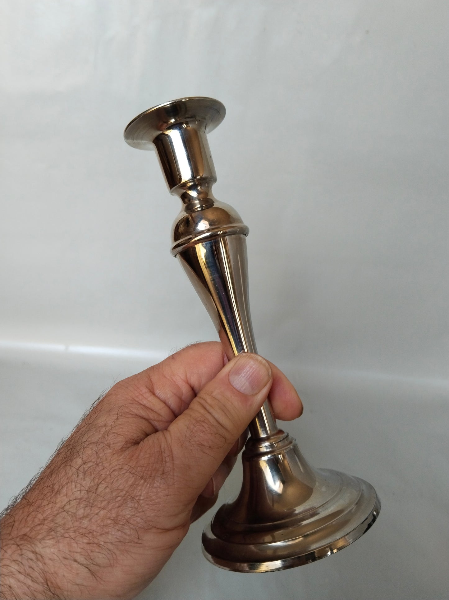 Eleganter-Vintage-Metall-Kerzenständer-17cm-poliert in einer Männerhand.