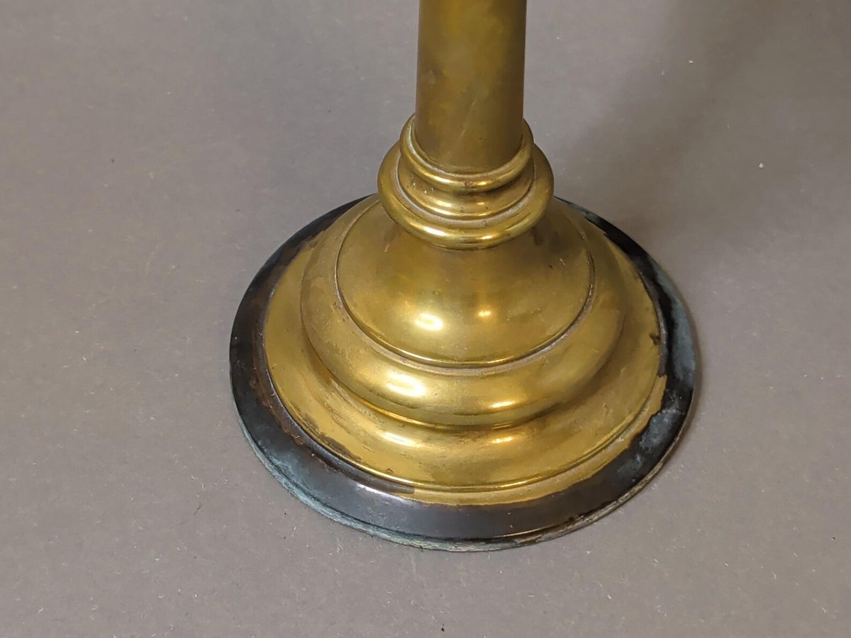 Detail Stufenfuß des Messing-Kerzenständers mit gedrechselten Ringen und dunkel patiniertem Rand
