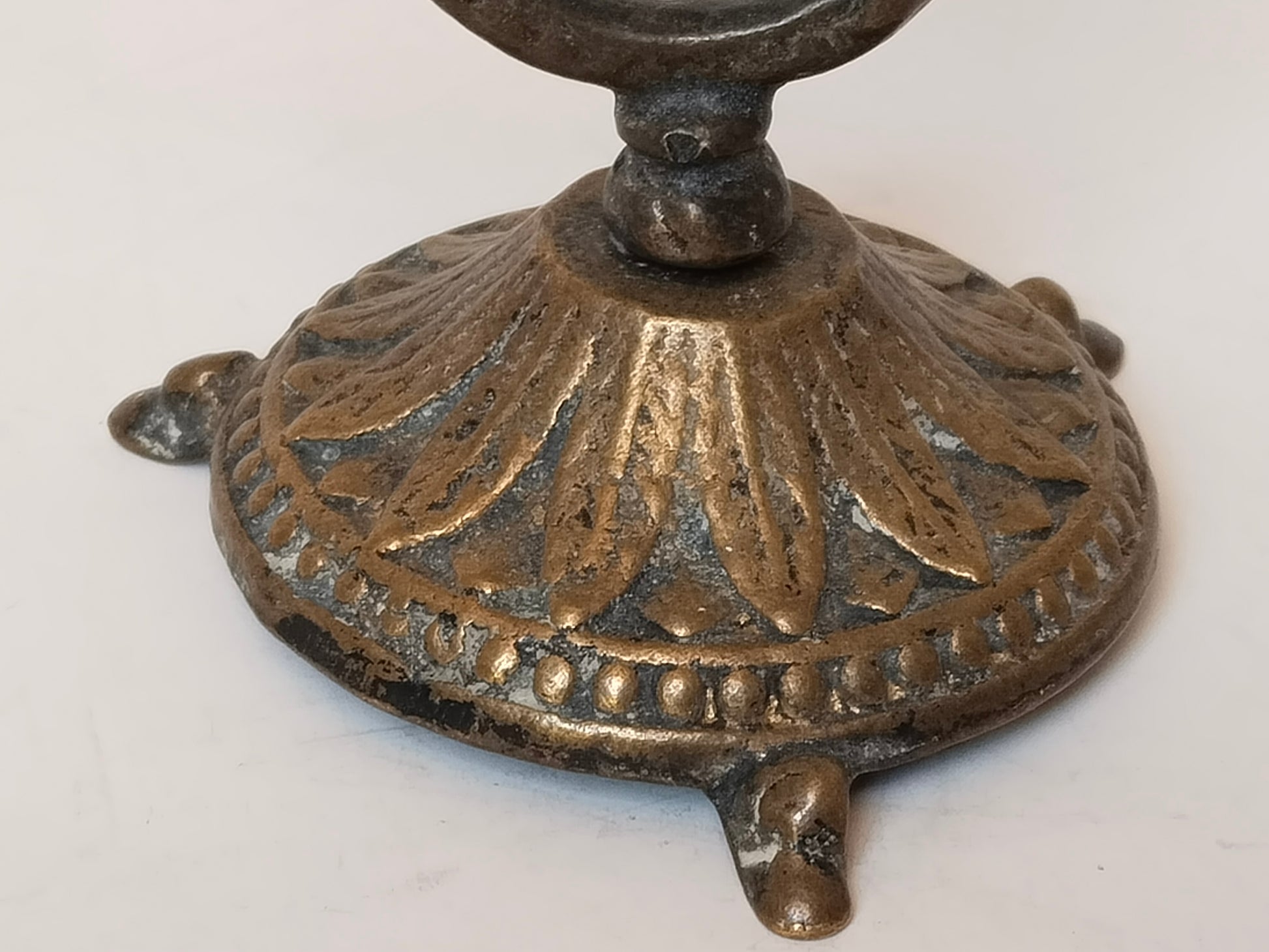 Detailansicht Fußplatte mit Blattmotiv und Perlrand