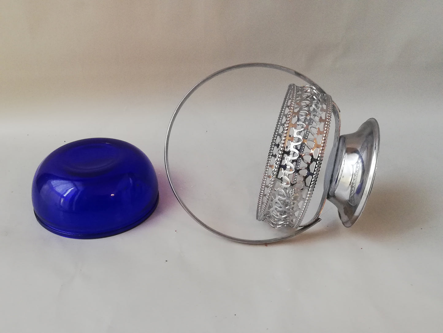Vintage Glasschale blau mit versilbertem Rahmen.
Halterung liegend, blaue Schale auf dem Kopf stehend.