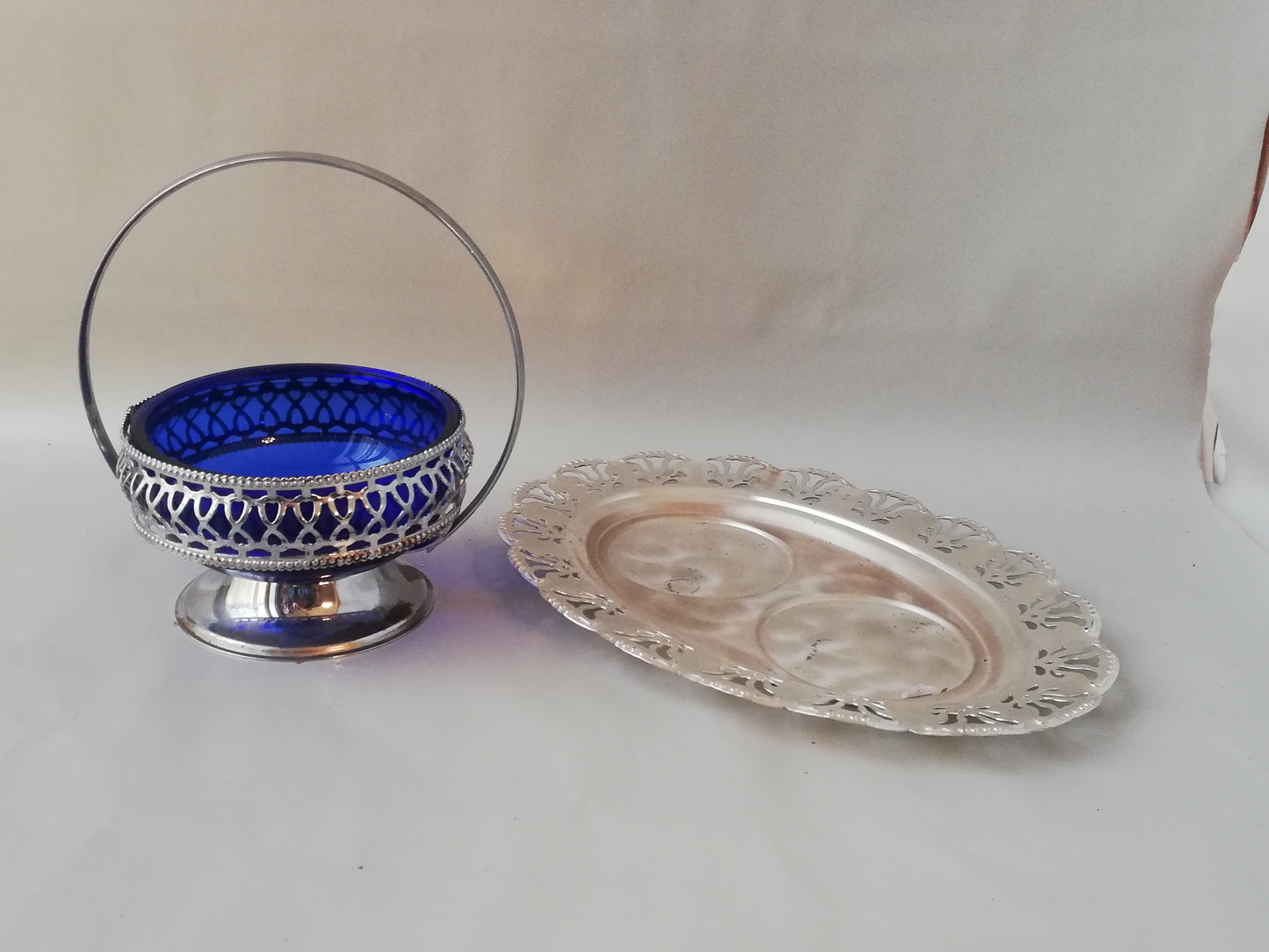 Vintage Glasschale blau mit versilbertem Rahmen neben einem versilberten Tablett.