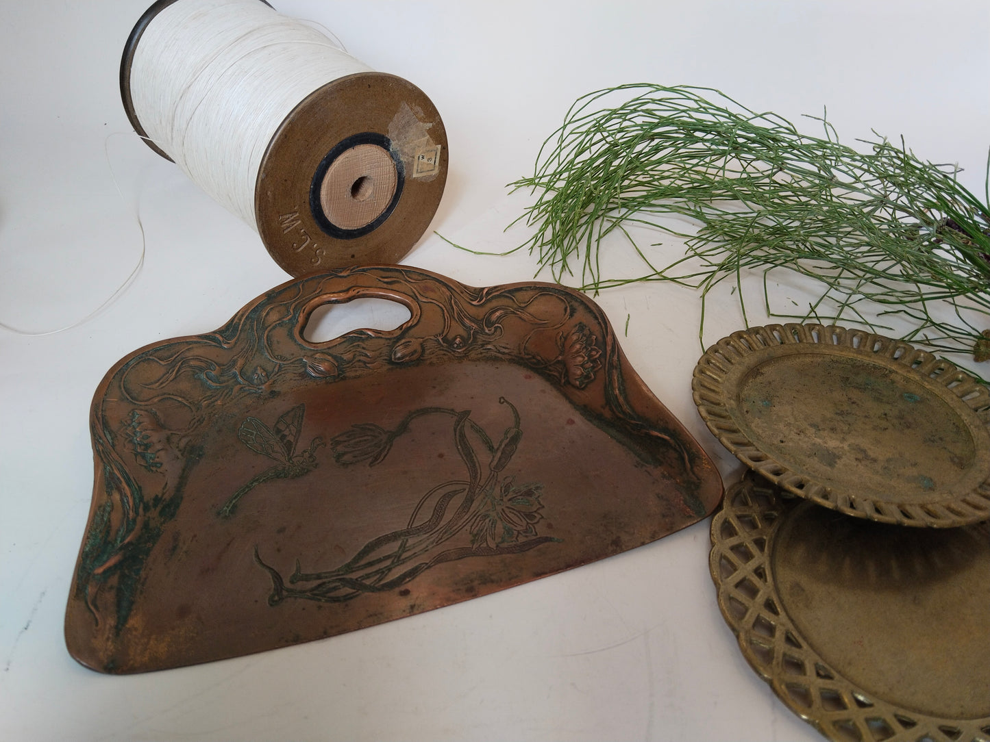 Antike Kupferschaufel Jugendstil in Szene mit alter Garnrolle, Sammlerstück

