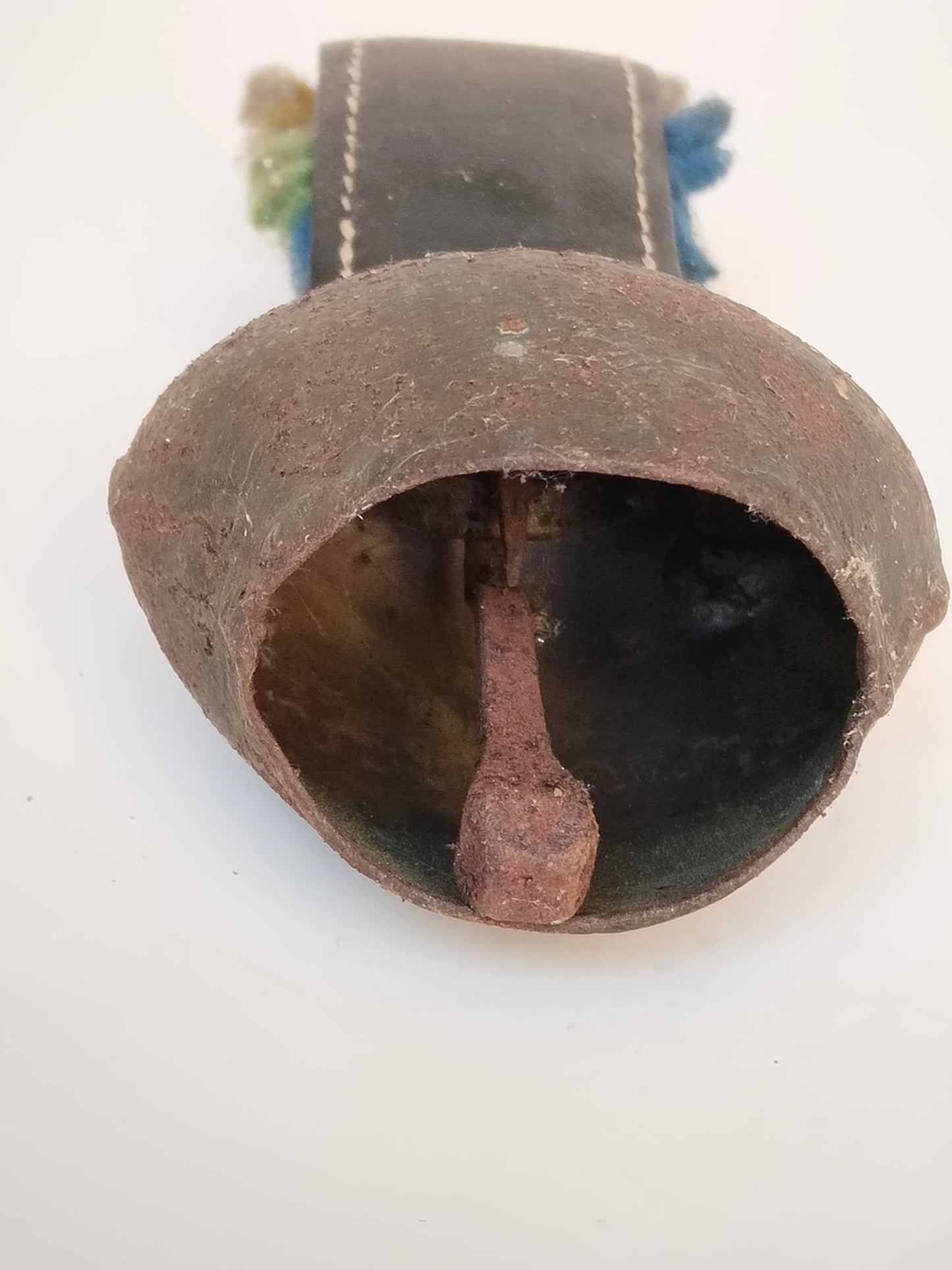 Vintage Almglocke von oben mit sichtbarem Eisen-Klöppel im Inneren
