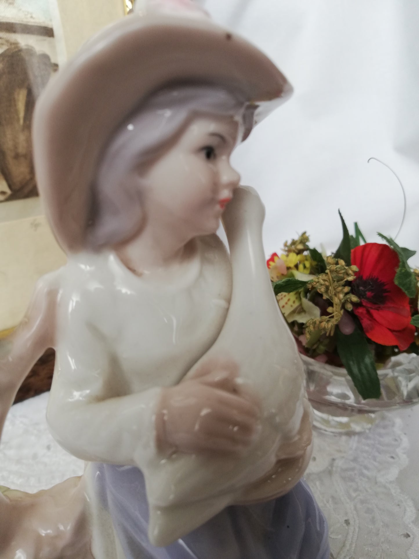 Porzellanfigur Mädchen mit Gans auf Stein. Nahaufnahme Gans von hinten.