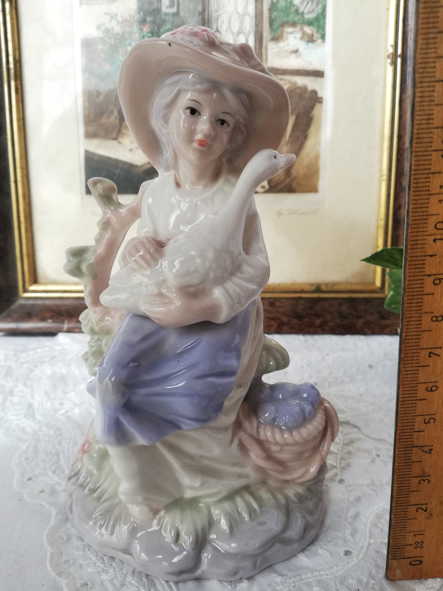 Porzellanfigur Mädchen mit Gans auf Stein. Aufnahme von vorne.