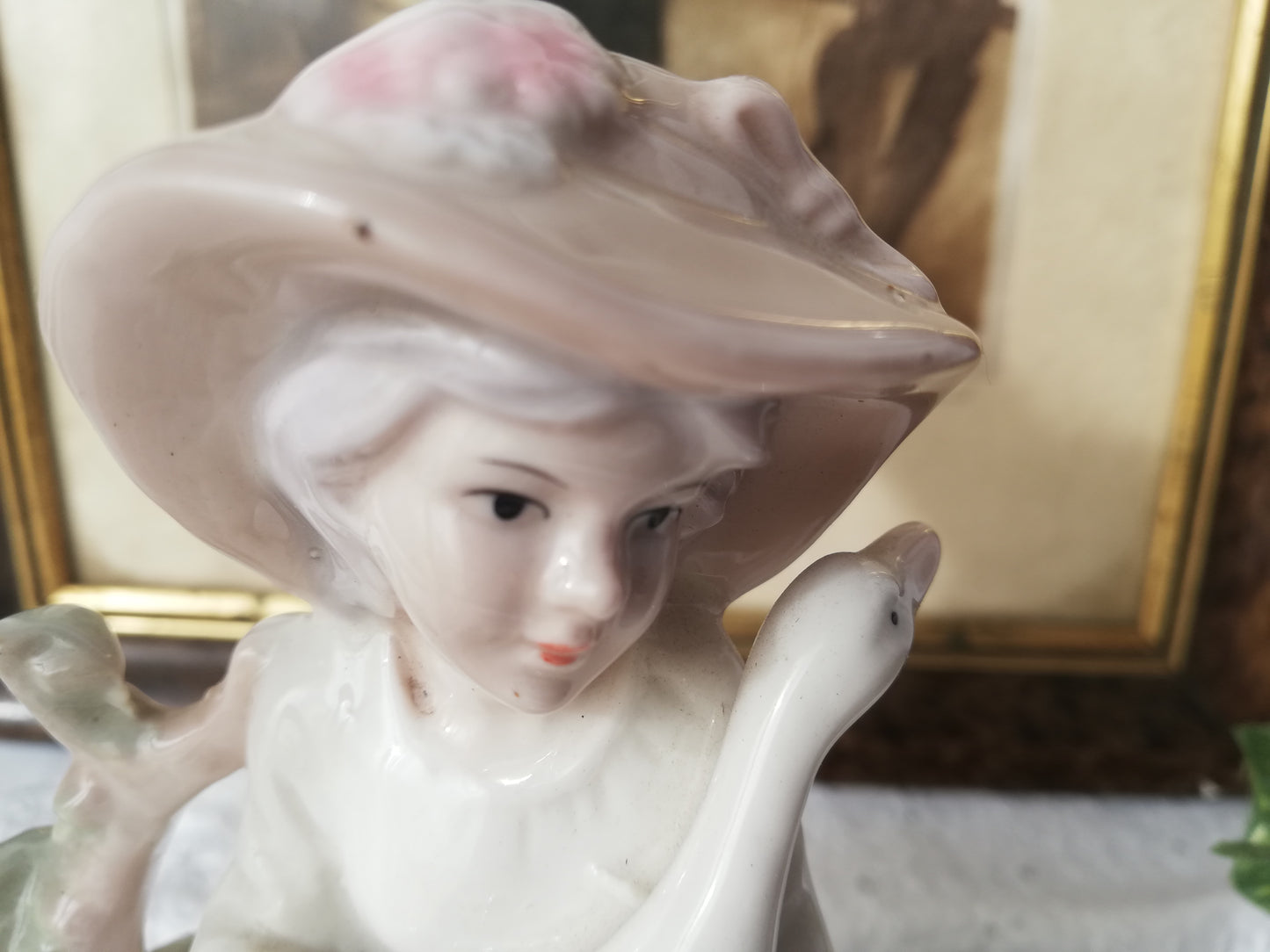 Porzellanfigur Mädchen mit Gans auf Stein. Nahaufnahme  Gesicht.