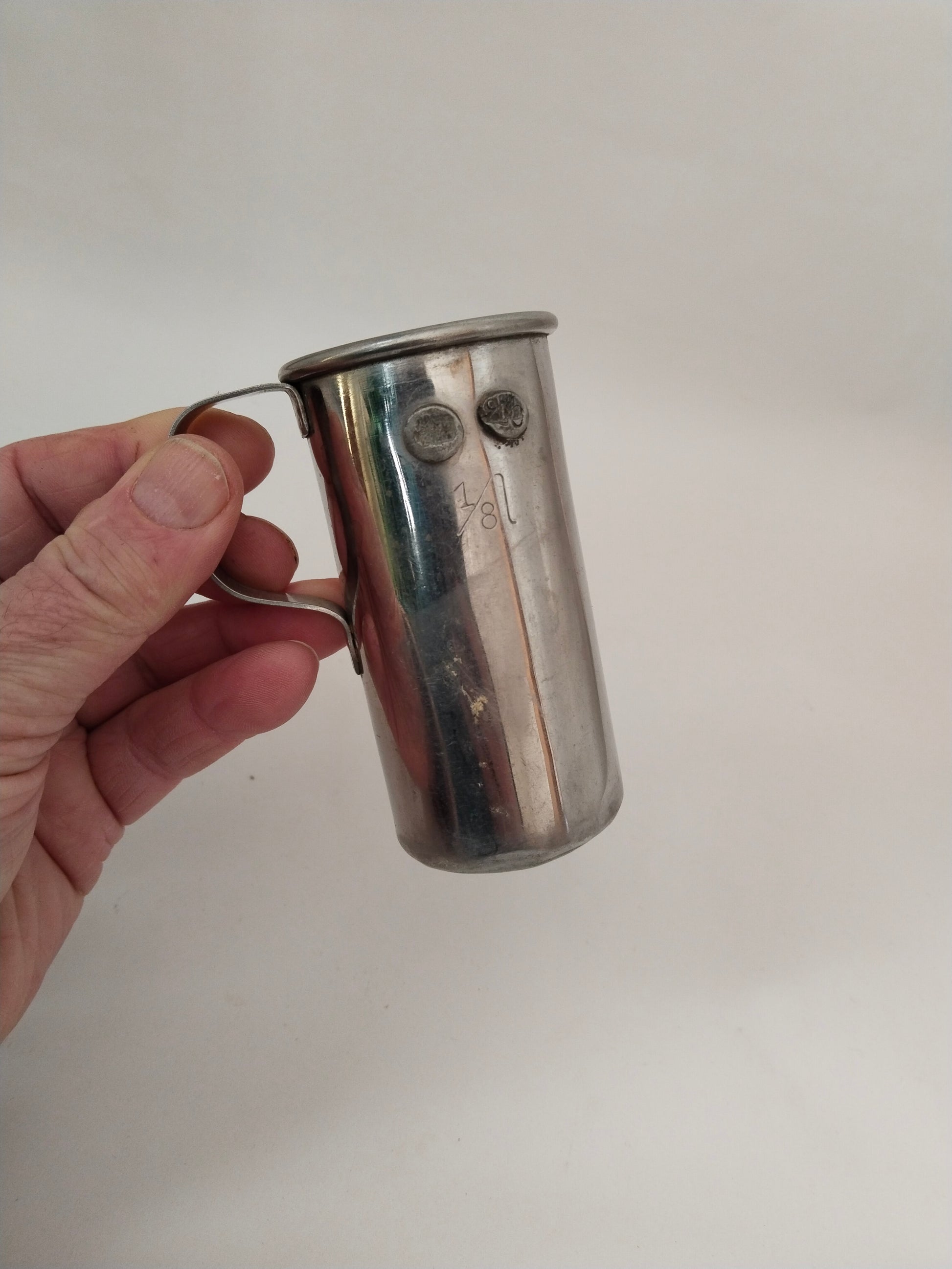 Antiker Messbecher 1/8 Liter Ideal Austria in einer Hand für den Größenvergleich
