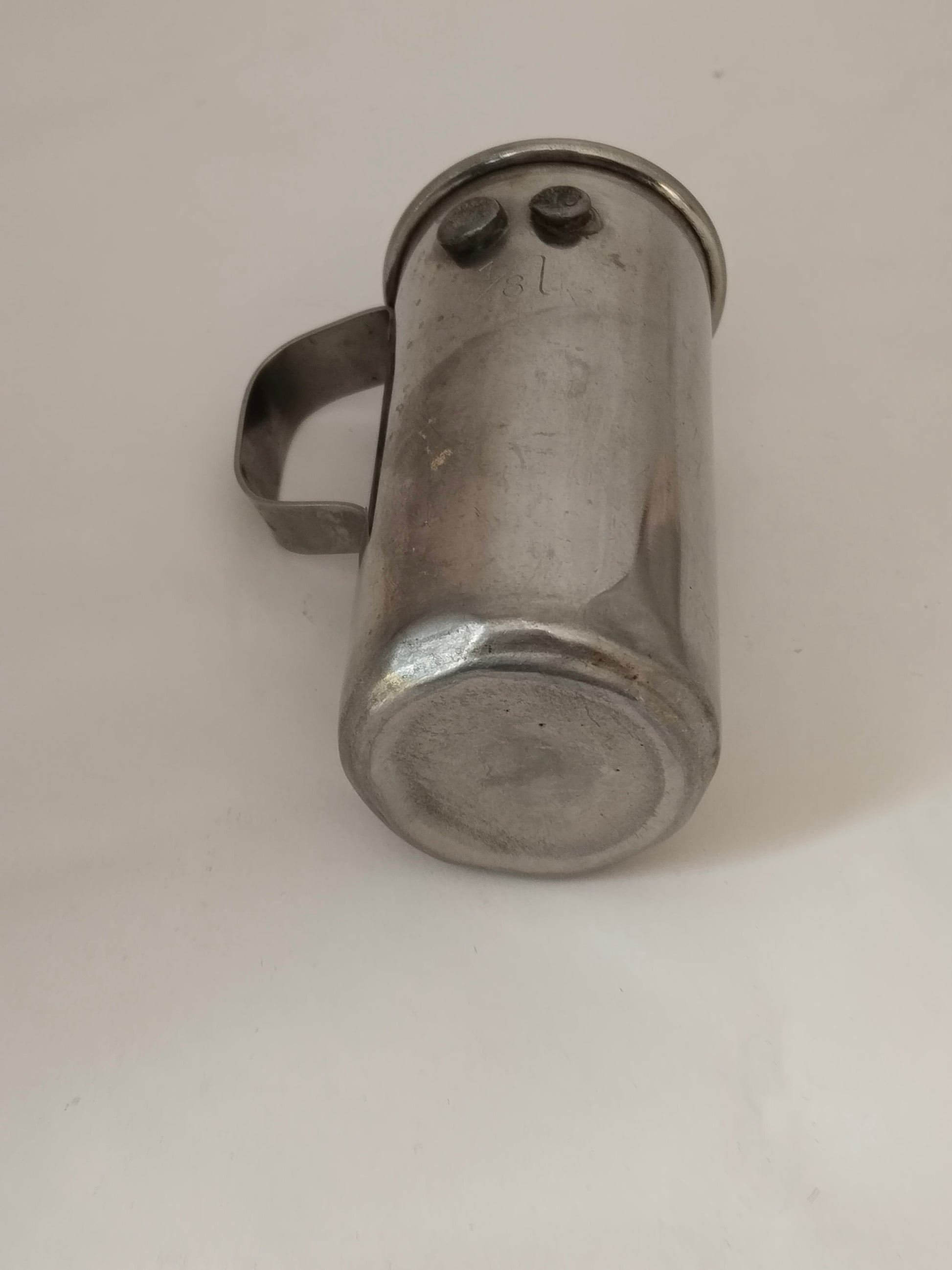 Antiker Messbecher 1/8 Liter Ideal Austria, liegende Ansicht mit Sicht auf den Boden.