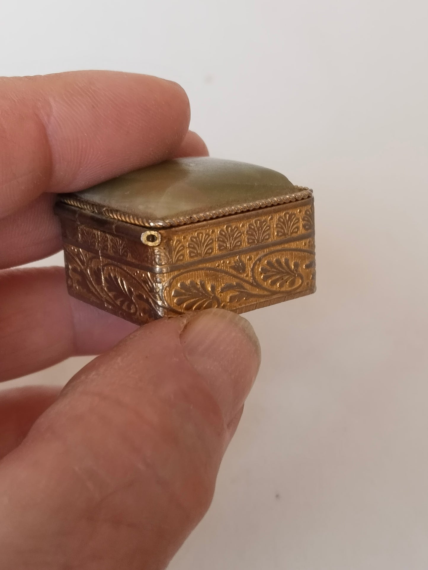 Größenvergleich in Hand, zeigt Miniaturformat der Pillendose