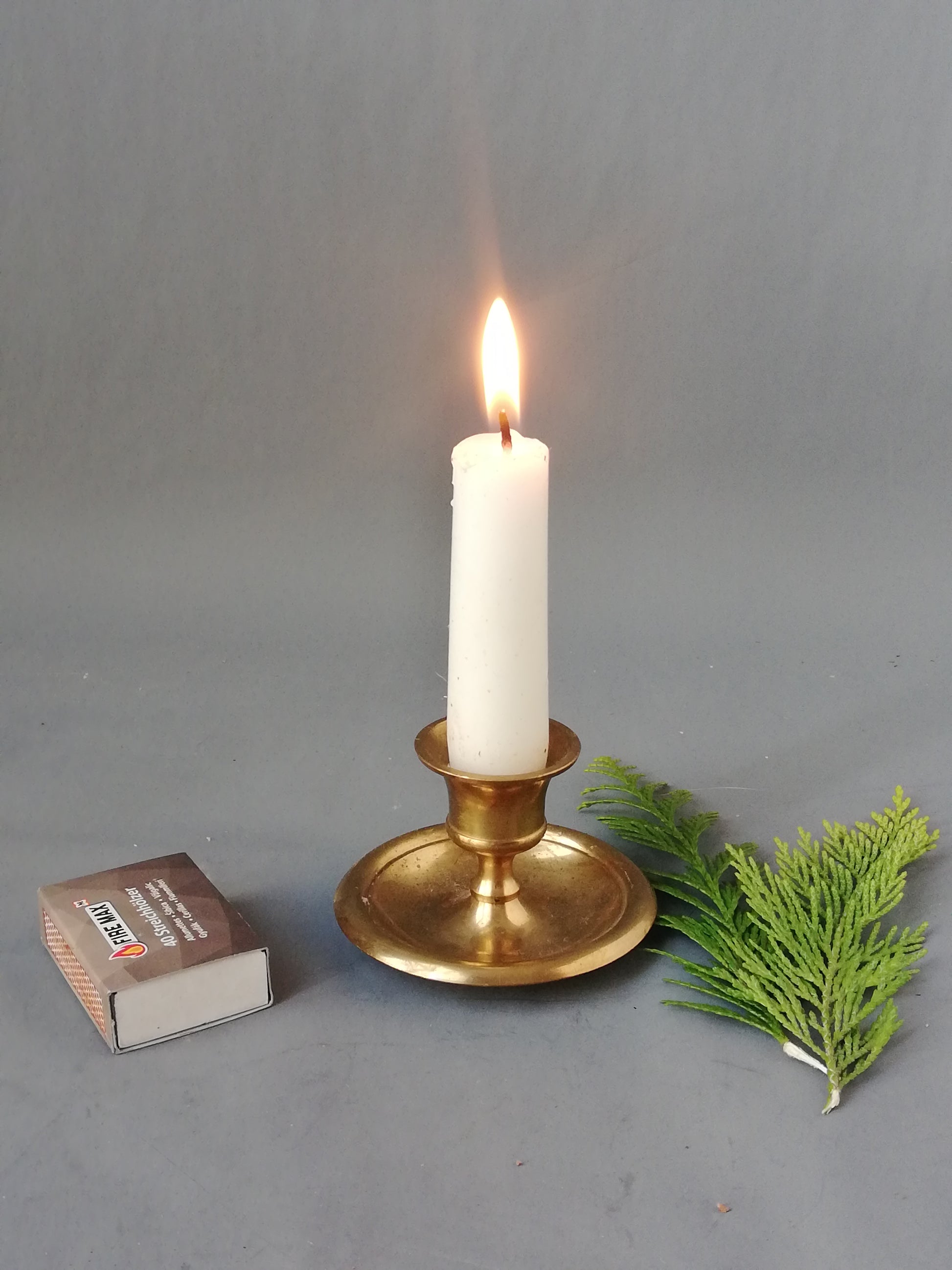 Messing-Kerzenständer-mit-brennender-Stabkerze-Streichhölzer