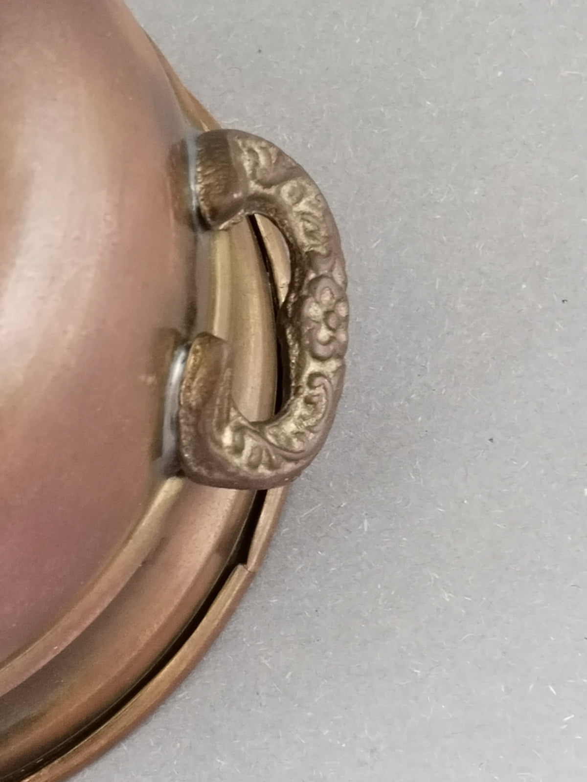 Detailaufnahme eines Messing-Ringgriffs mit gepunztem Blütenornament