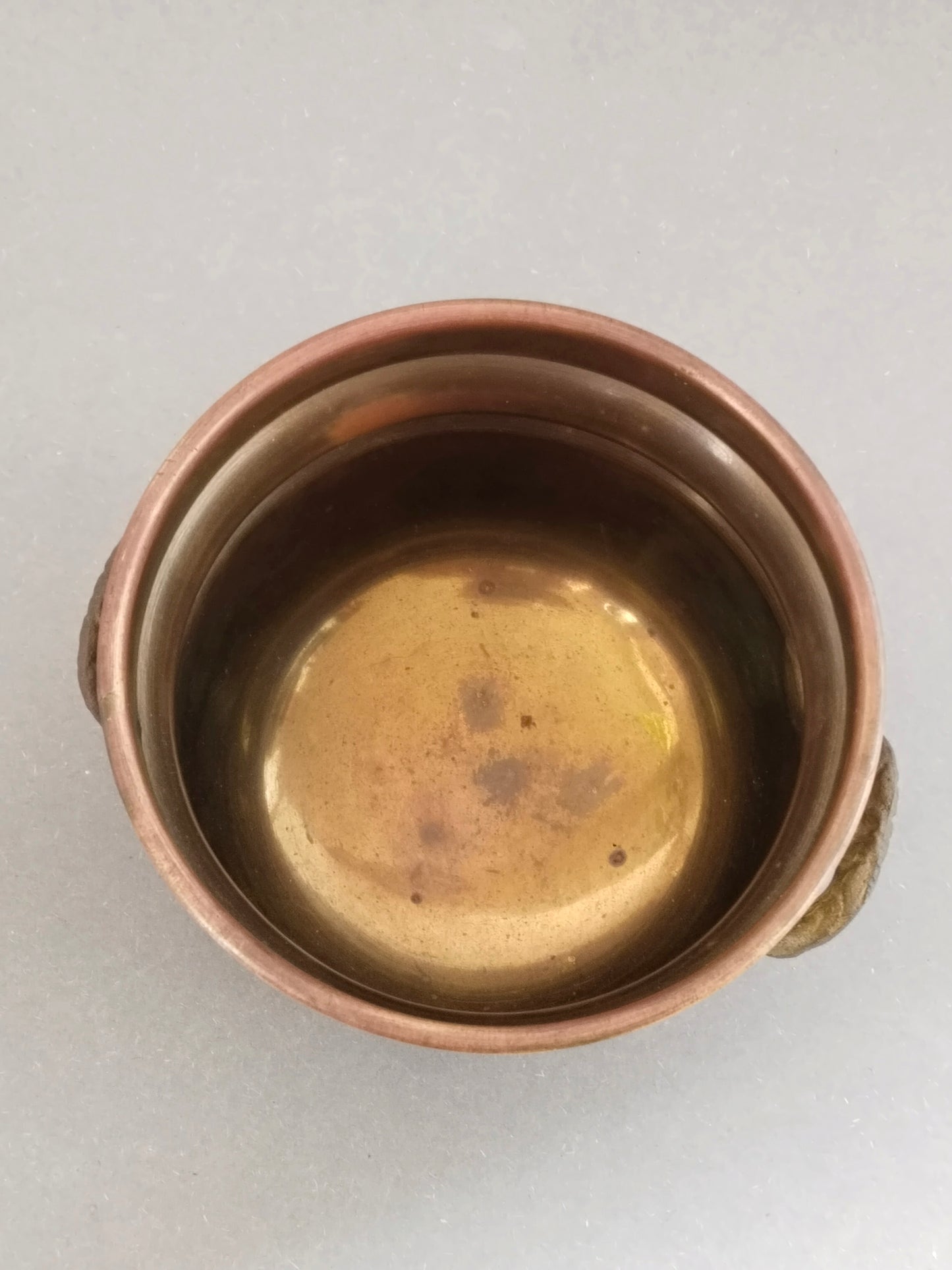 Innenansicht von oben: goldgelber Messingboden mit dunklen Alterungsflecken