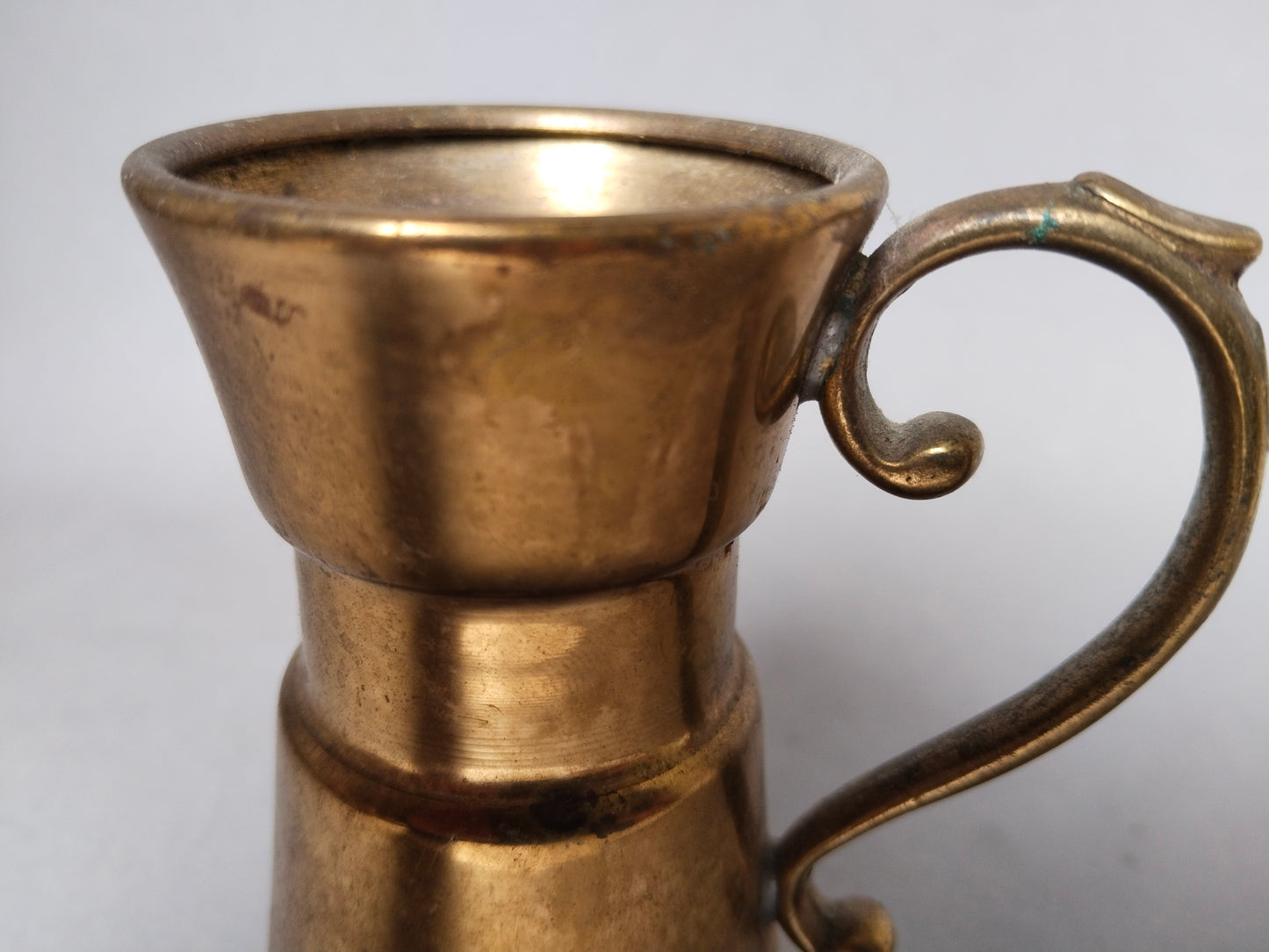 Detailansicht des geschwungenen S-Henkels mit Kugelabschlüssen, Messing Patina