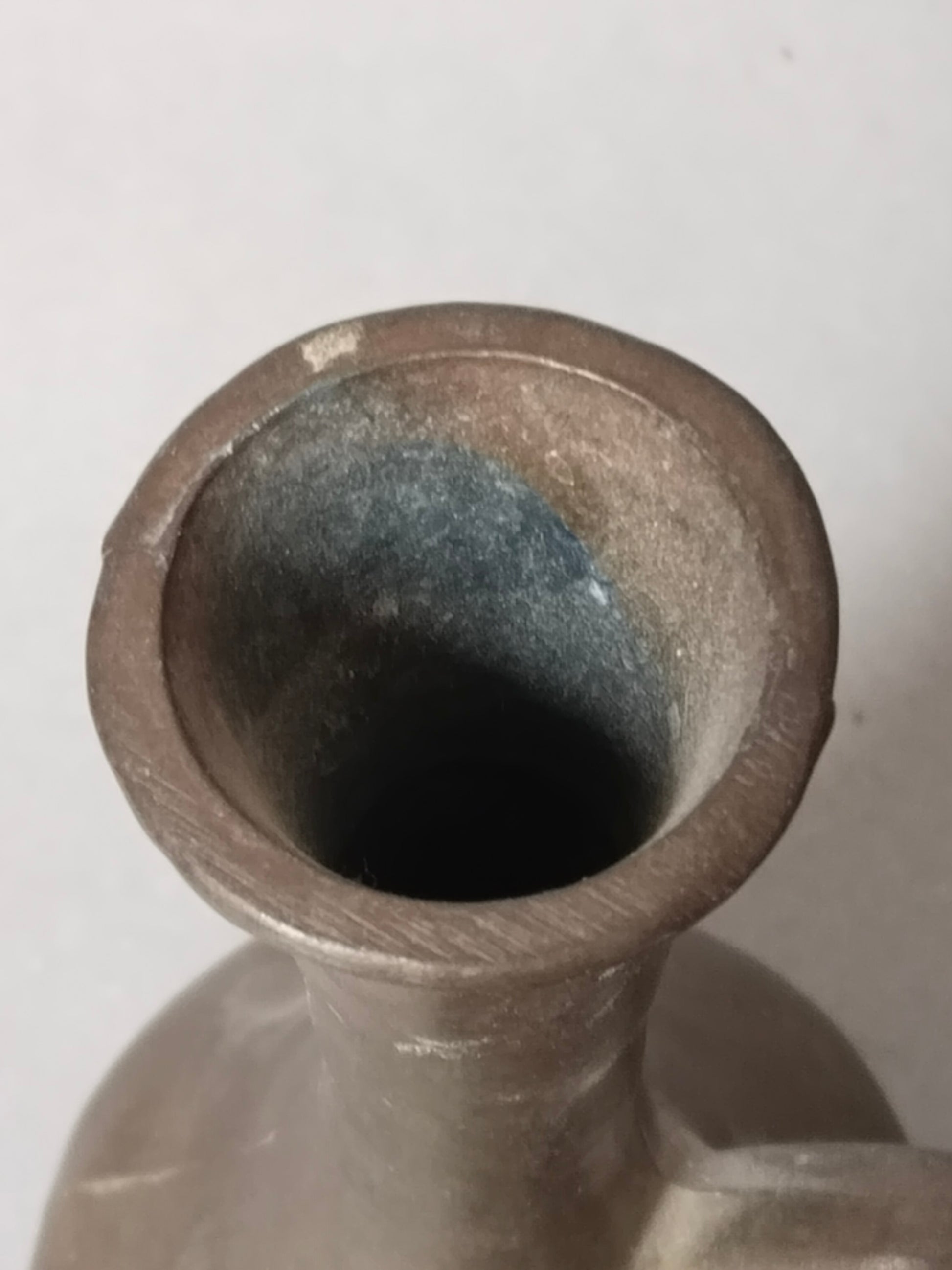 Blick in die dicke Oeffnung der massiv gegossenen Metallvase