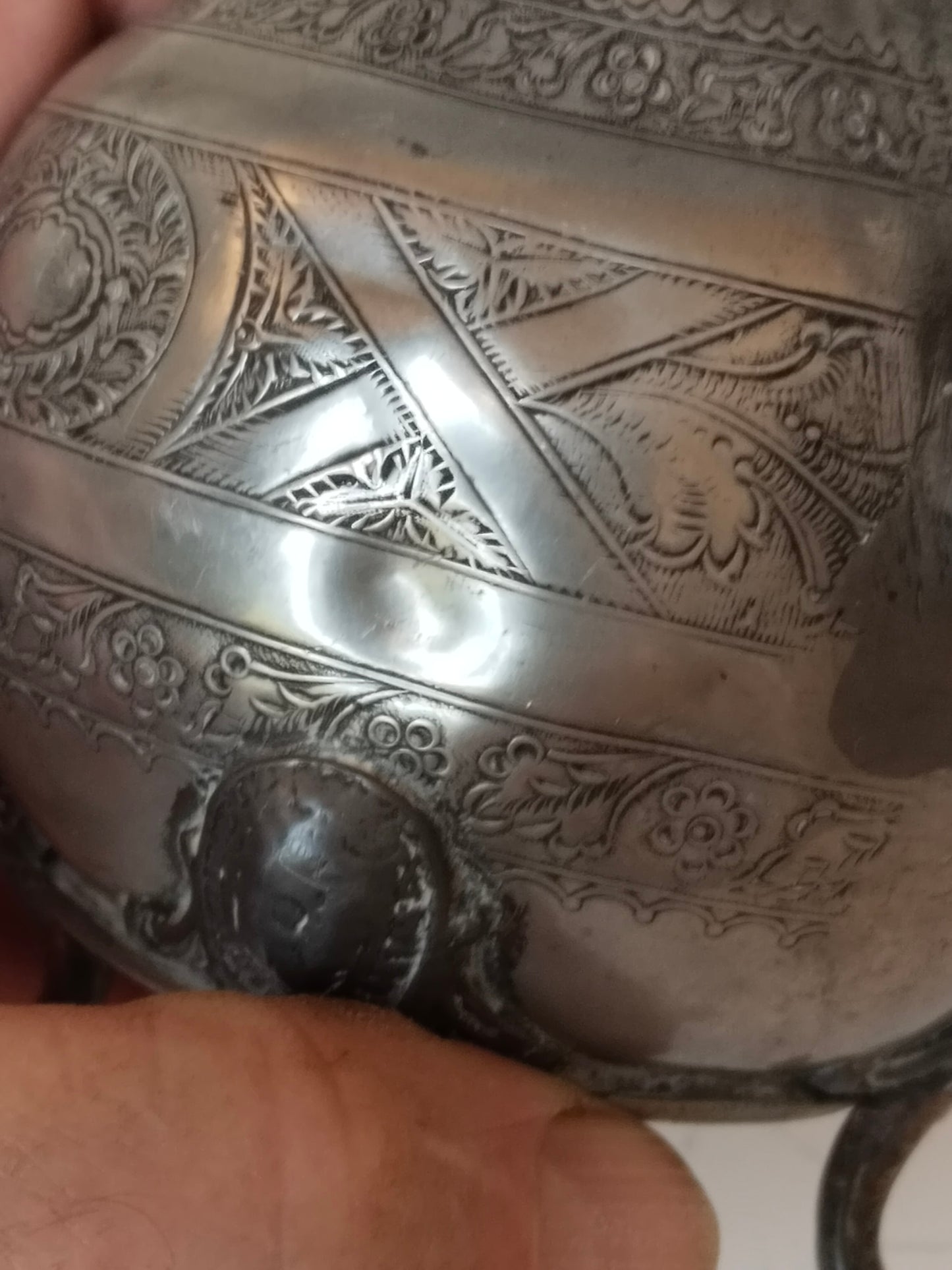 Nahaufnahme der Wandung mit sichtbarer kleiner Delle im gravierten Muster
