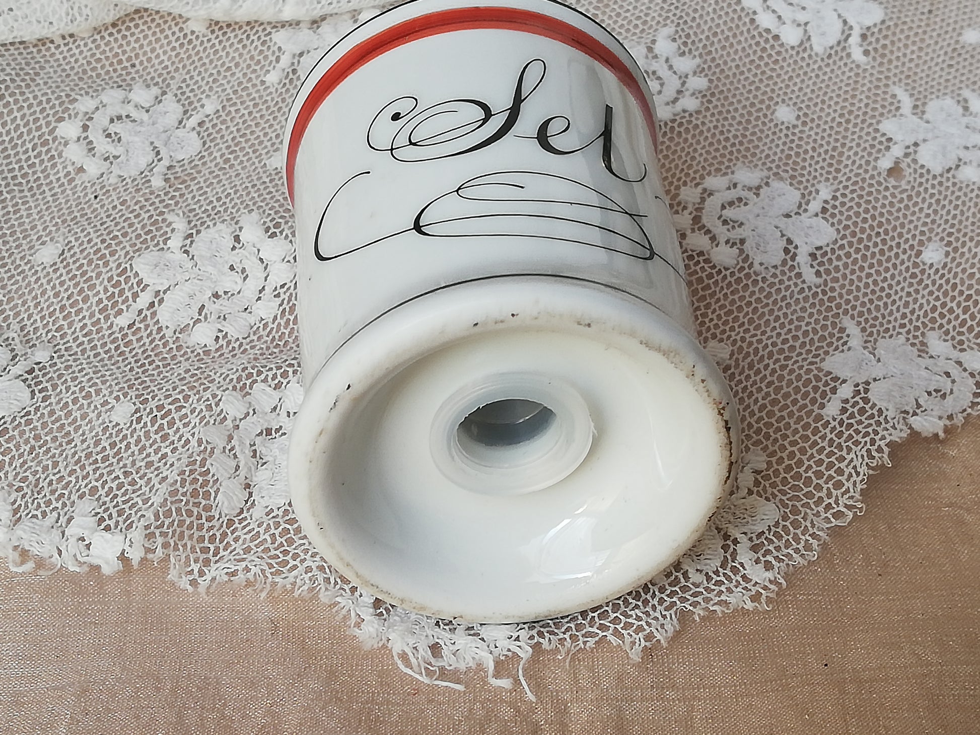 Kleiner Porzellansalzstreuer im französischen Design. Ansicht von unten mit Öffnung für Salzzufuhr.