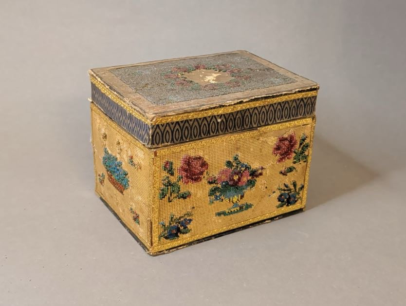 Antikes Schmuckkästchen mit Glasperlenstickerei, Schrägansicht auf die Vorderseite mit Blumenschale, Rosen und blauen Blüten