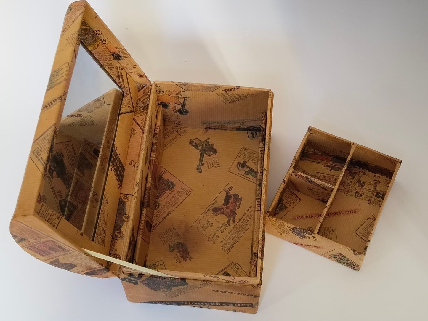 Geöffnetes Schminkkästchen mit danebenstehendem herausnehmbarem Einsatz für Puder und Pinsel