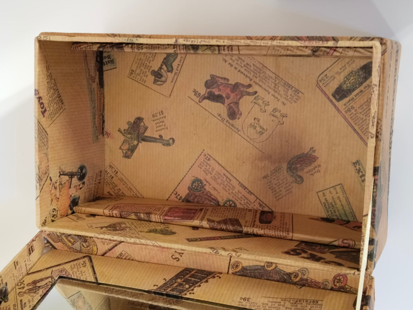 Innenraum des Schminkkästchens ohne Einsatz, rundum mit Papier ausgekleidet, Deckel geöffnet
