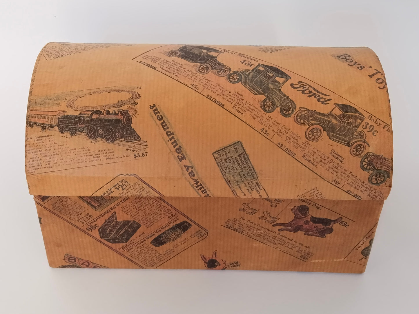 Vintage Schminkkästchen in Truhenform, geschlossen von vorne, Karton mit nostalgischem Spielzeugkatalog-Druck
